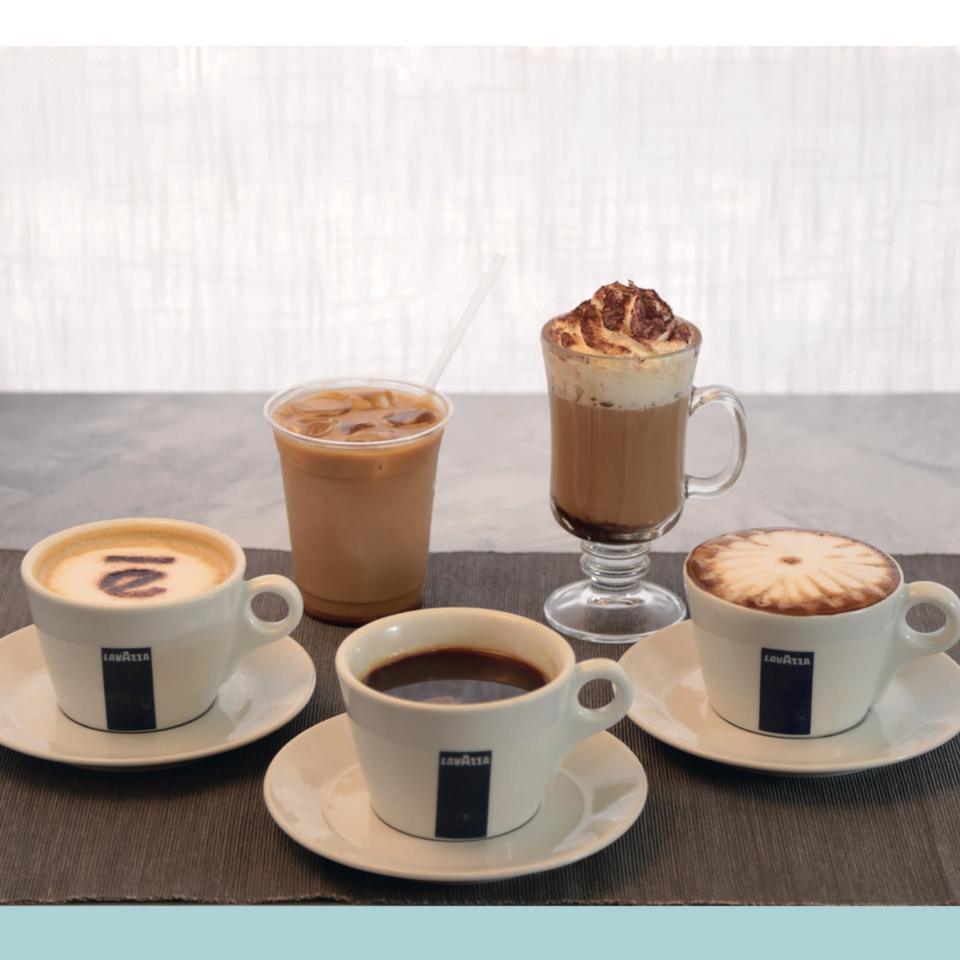 Four Lavazza coffee drinks: two lattes with art, an iced coffee, and a whipped cream mocha.
